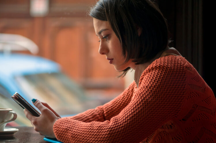 Woman checking her phone with serious face.