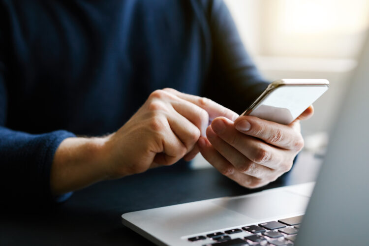 Male hand using smartphone in the office