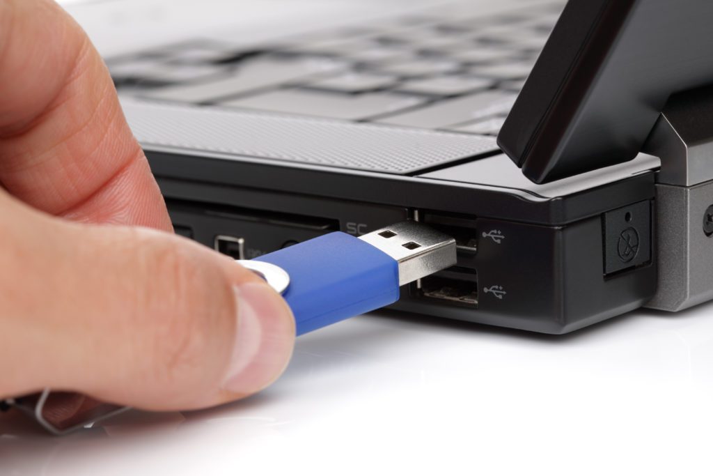 Connecting blue USB flash drive to a laptop.
