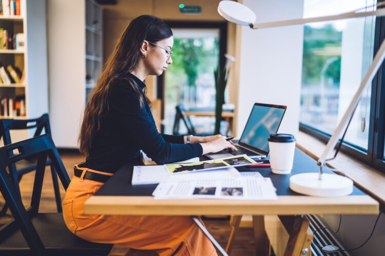 Stylish woman working on laptop in office