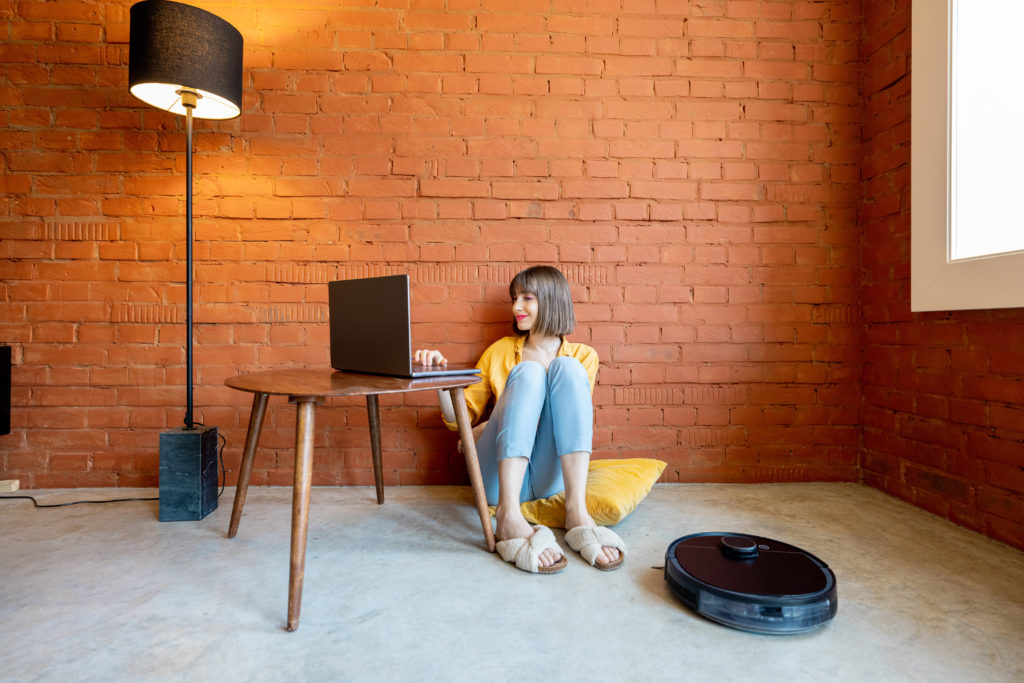 Woman using her laptop while sitting on the floor.