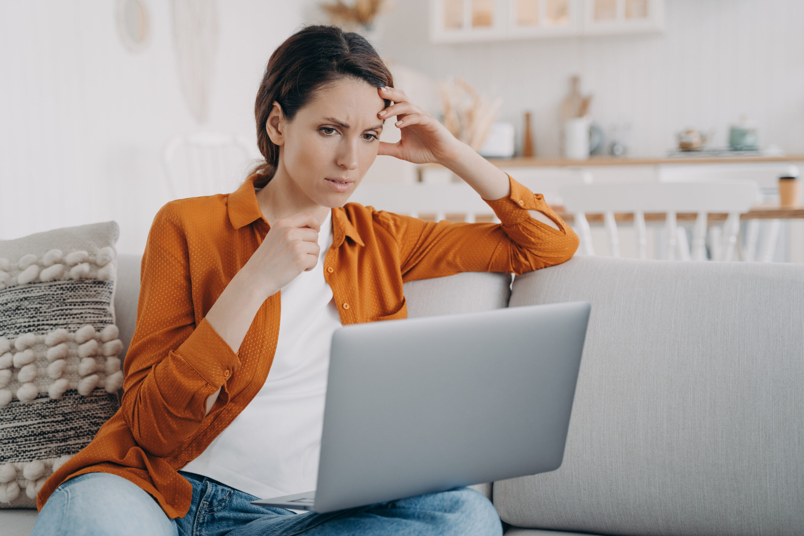 Puzzled woman intently watches a movie scene in her laptop