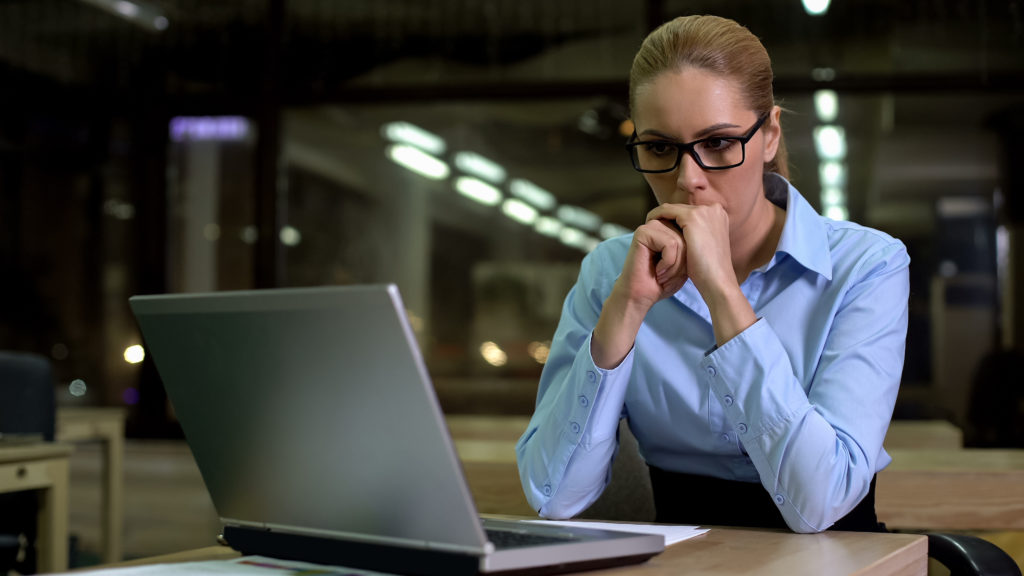 Working woman with a serious look staring at the laptop