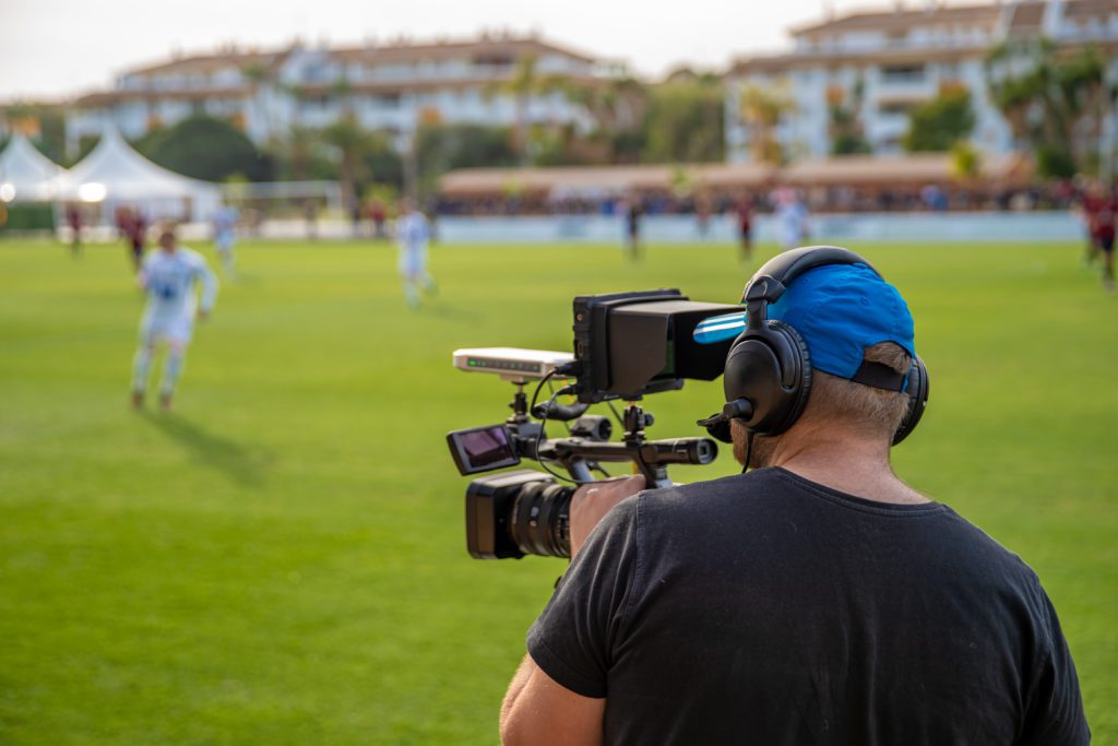 Cameraman shooting live broadcast from a soccer game.