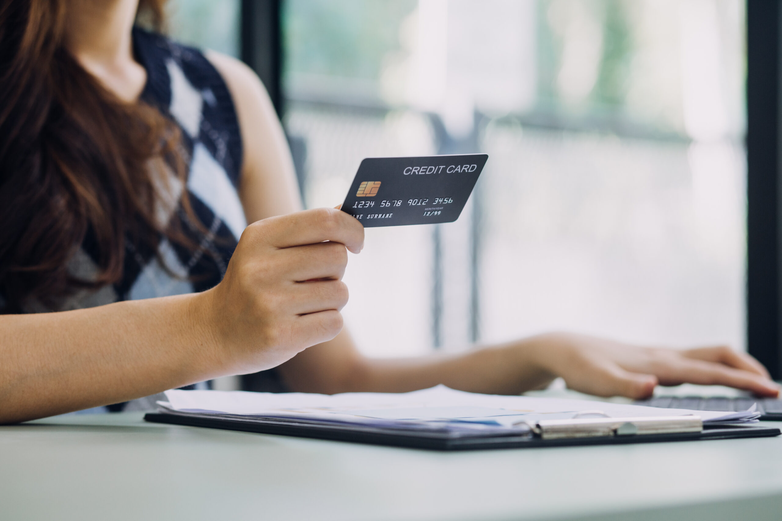 woman holding a credit card showing card digits 