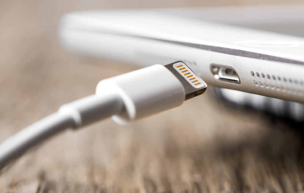 Charger with device on a wooden desk.