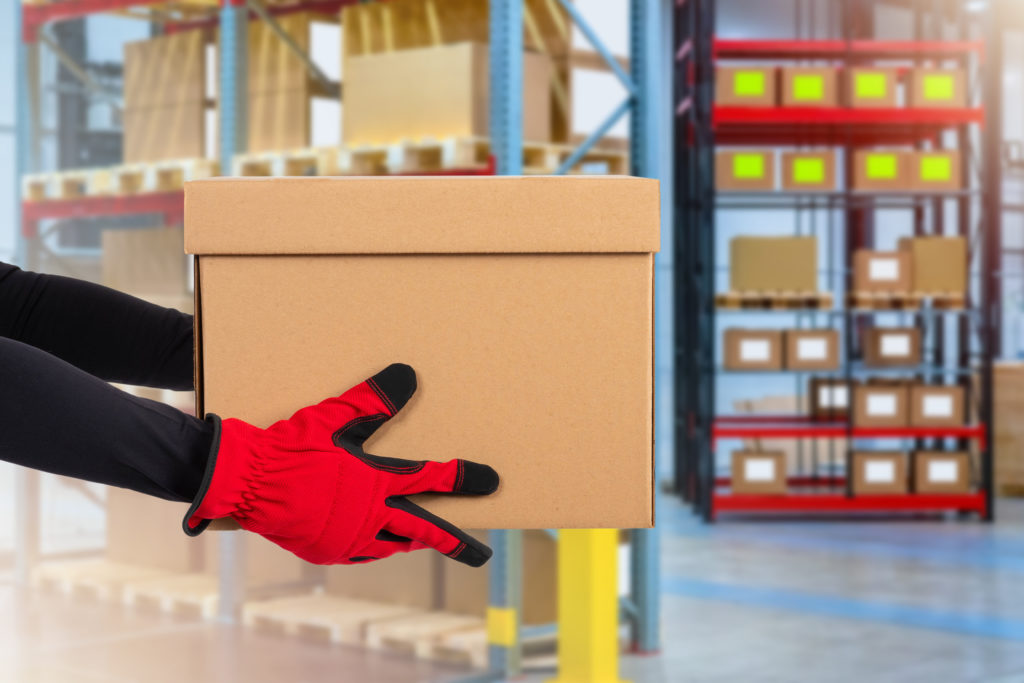 Delivery man holds out package box.