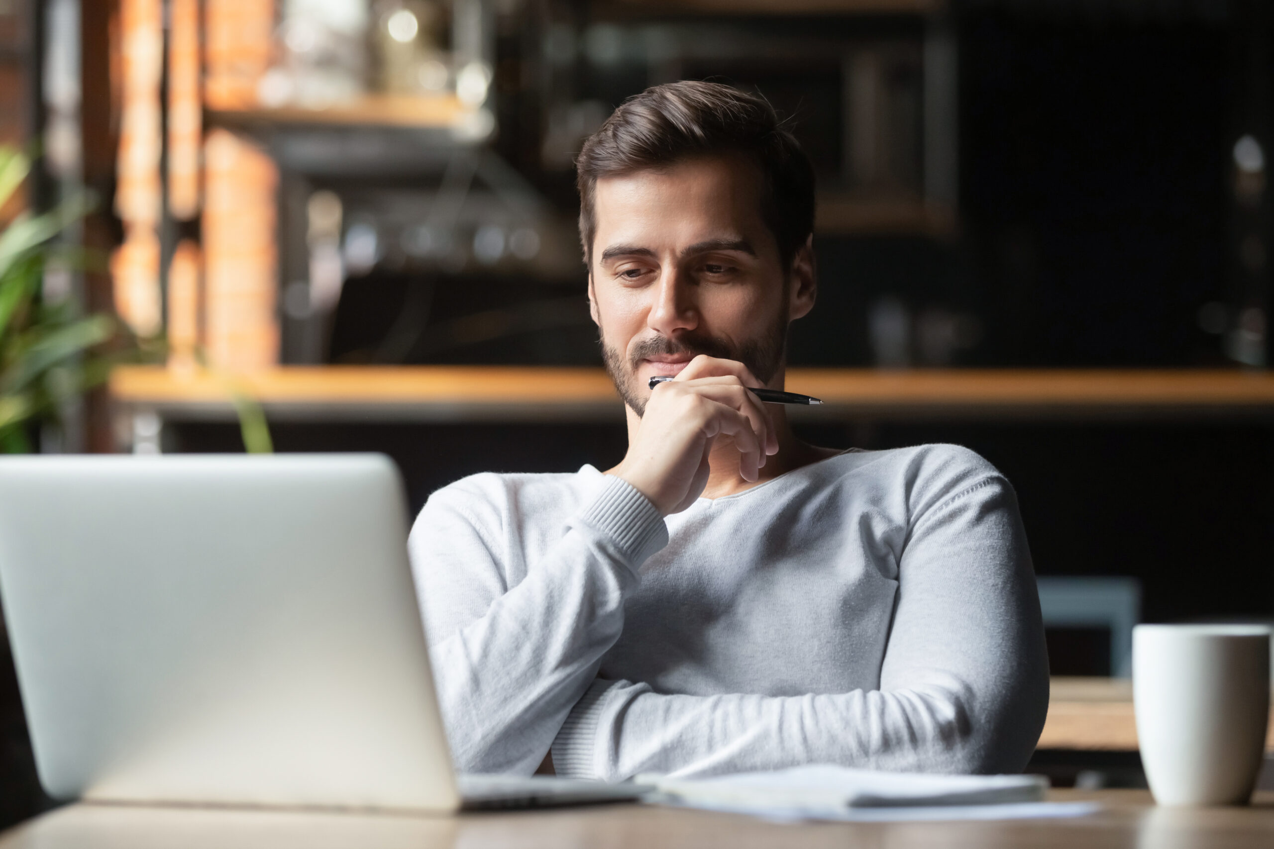 Thoughtful businessman think of online project looking at laptop