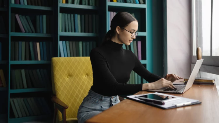 Female lawyer with glasses on face work at stylish office, uses laptop.