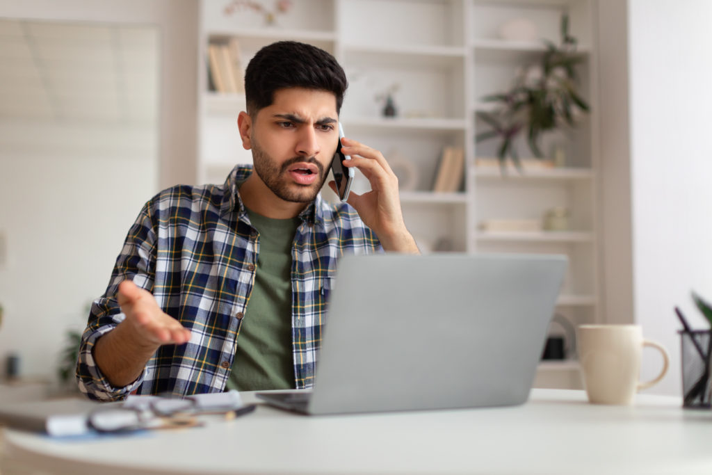 Confused Arab man talking on the phone.