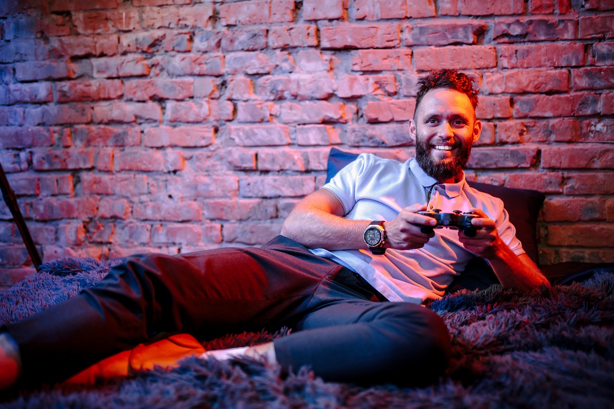 Guy playing video game console at home.