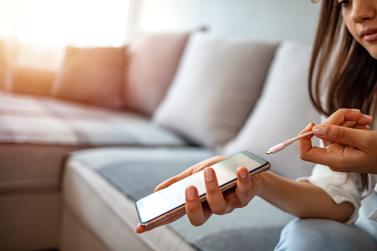 Woman hands plugging a charger on a smart phone. 