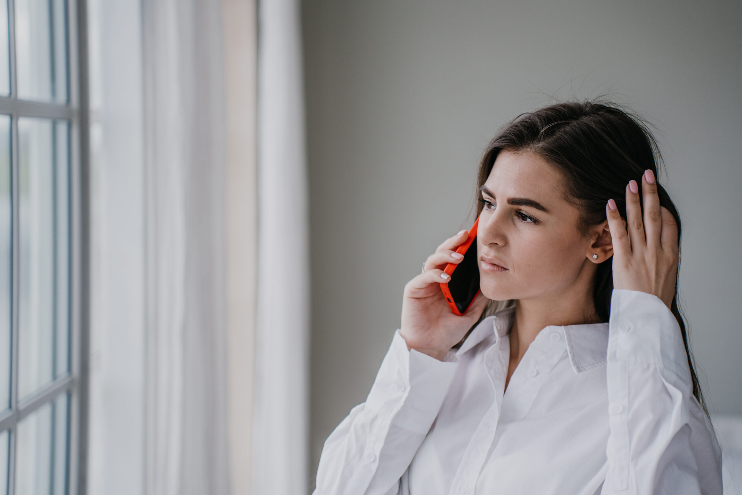 Frustrated young woman talking on the phone 