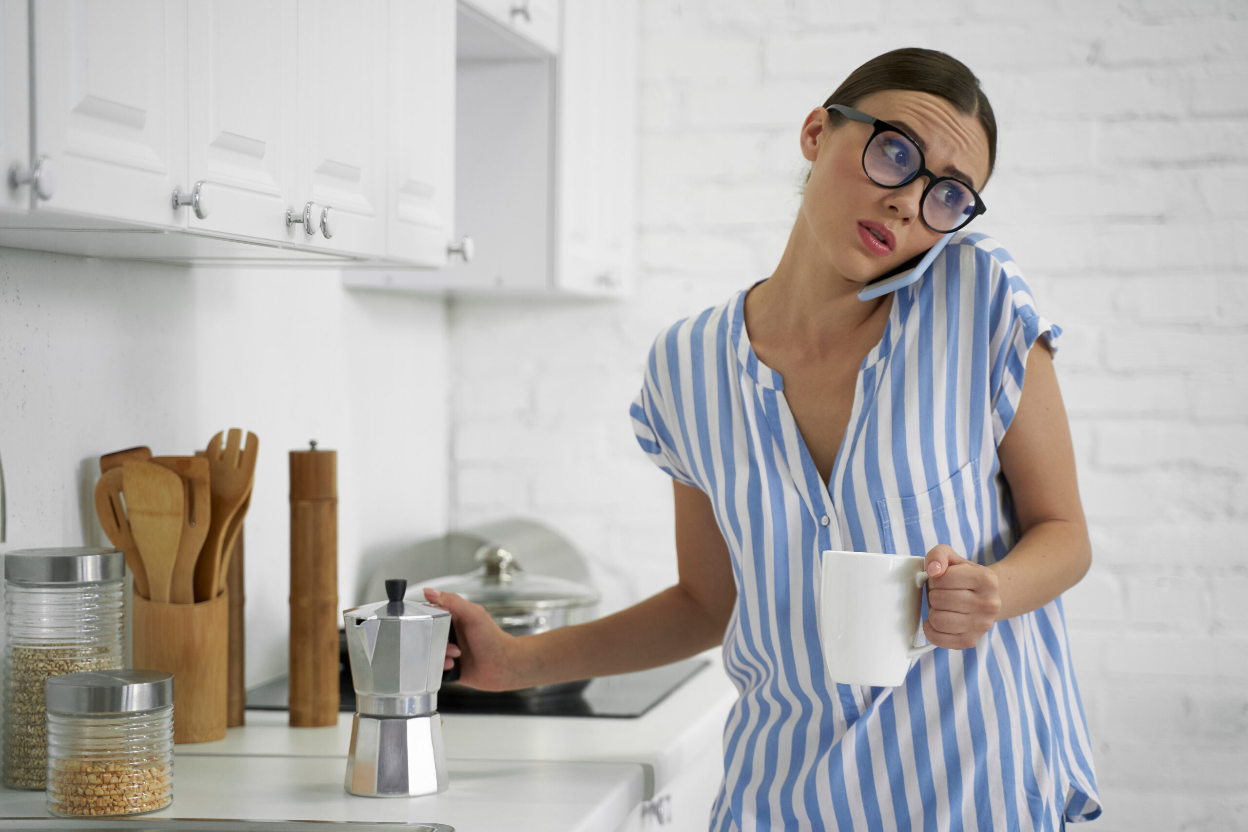 Frowning woman with coffee talking on the phone 