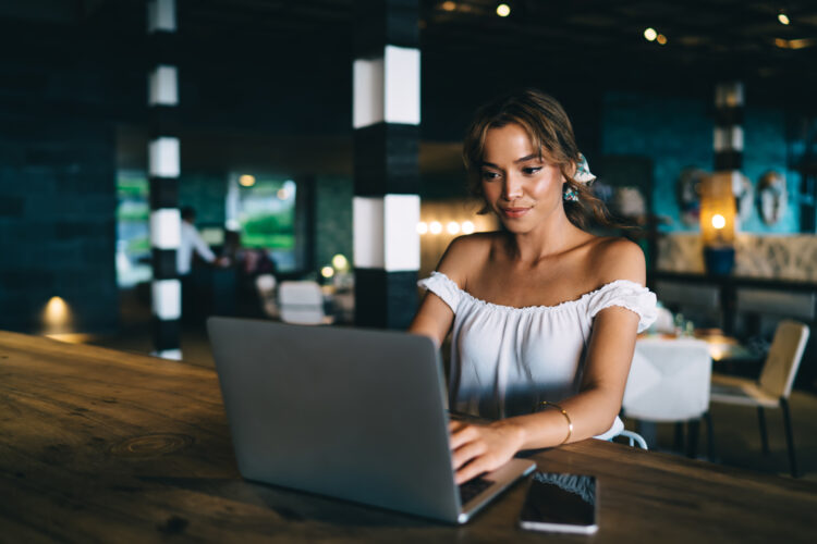 Young lady sitting in cafe while using computer