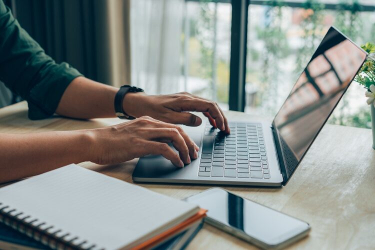 Tangan pria bekerja di laptop di kantor