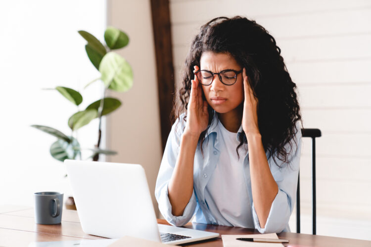 Exhausted young african-american professional woman stressed at work