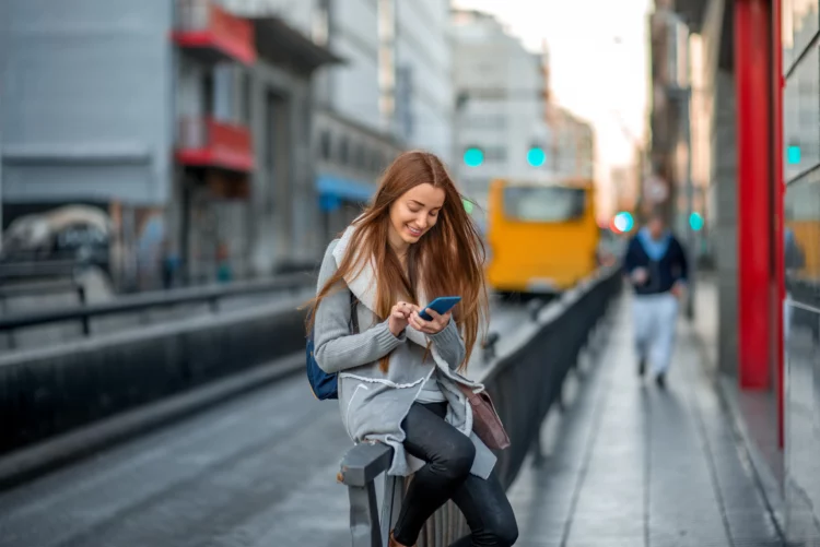 attractive young woman with phone in the city