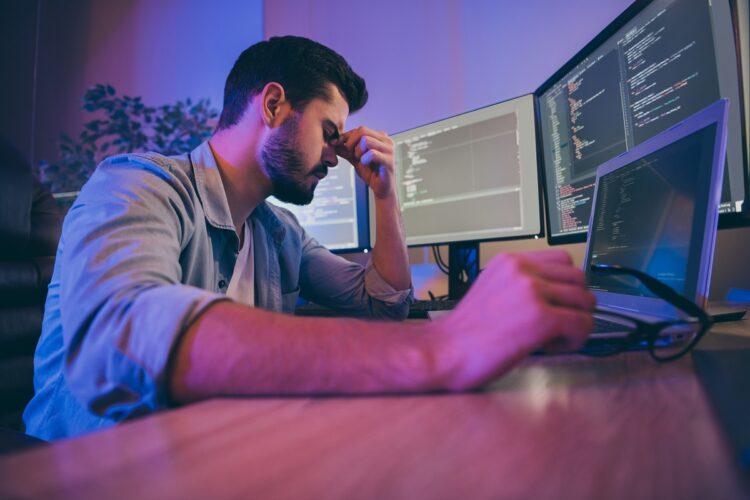 Sad and exhausted programmer at his workstation