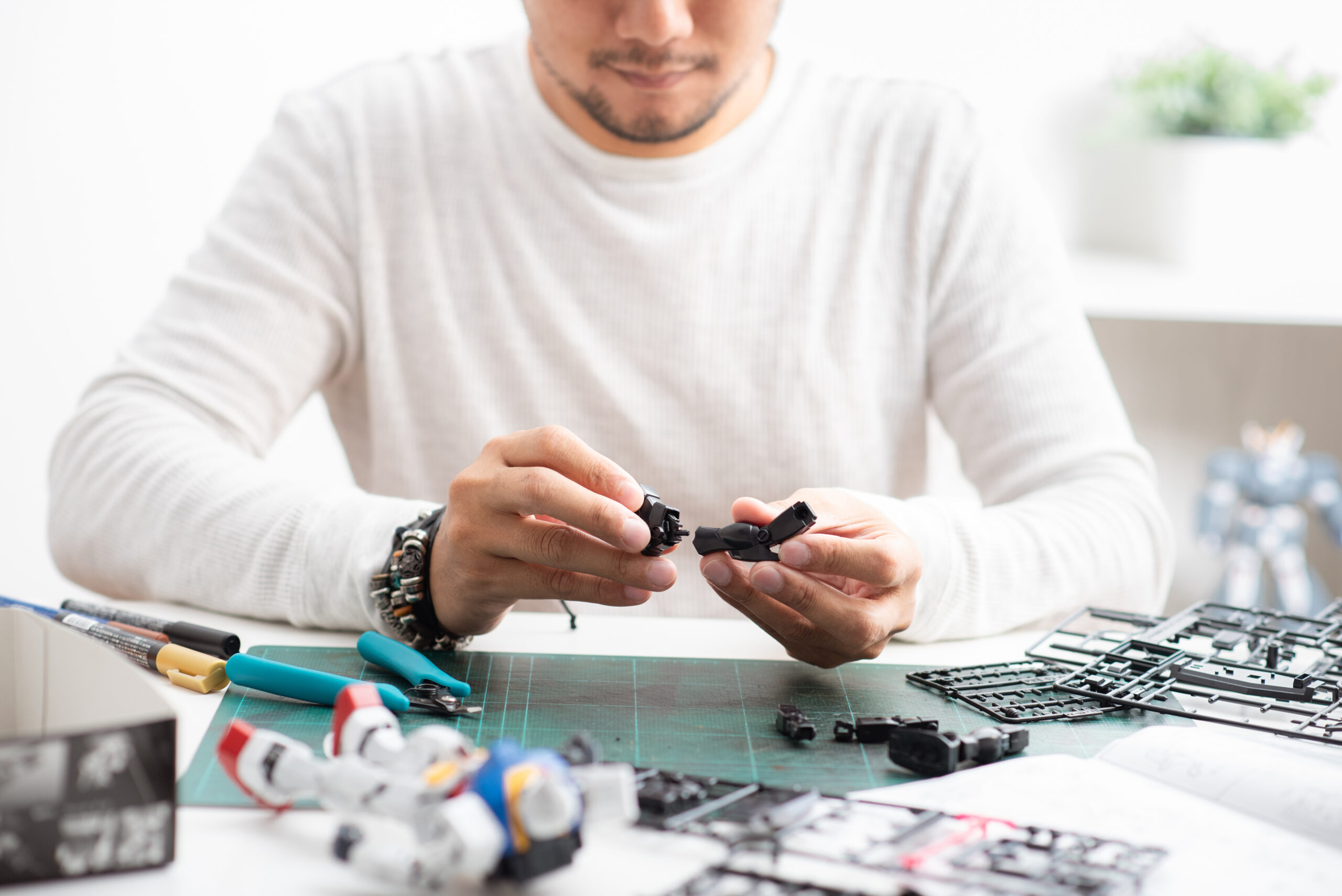Man assembling plastic anime models