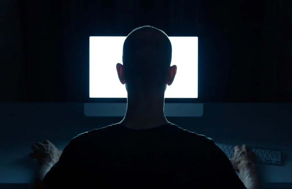 Man with criminal intentions using desktop computer.