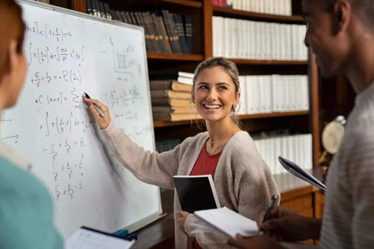 Happy student solving a math problem on a whiteboard