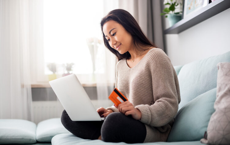 Asian girl making online payment using laptop for shopping at home