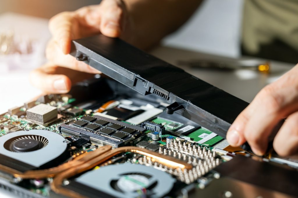 Technician replaces laptop battery.