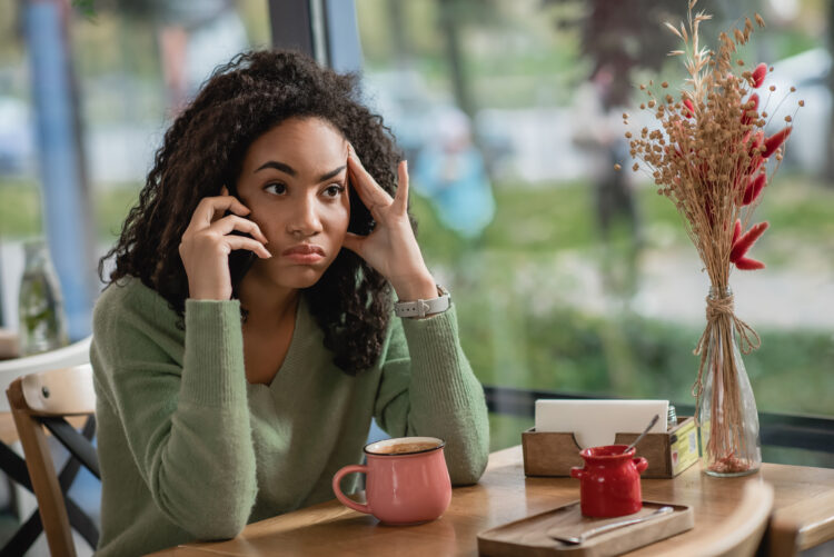 displeased woman puffing cheeks while talking on phone