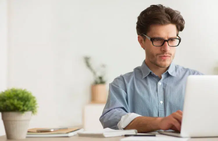 focused and serious guy checking something out on his laptop