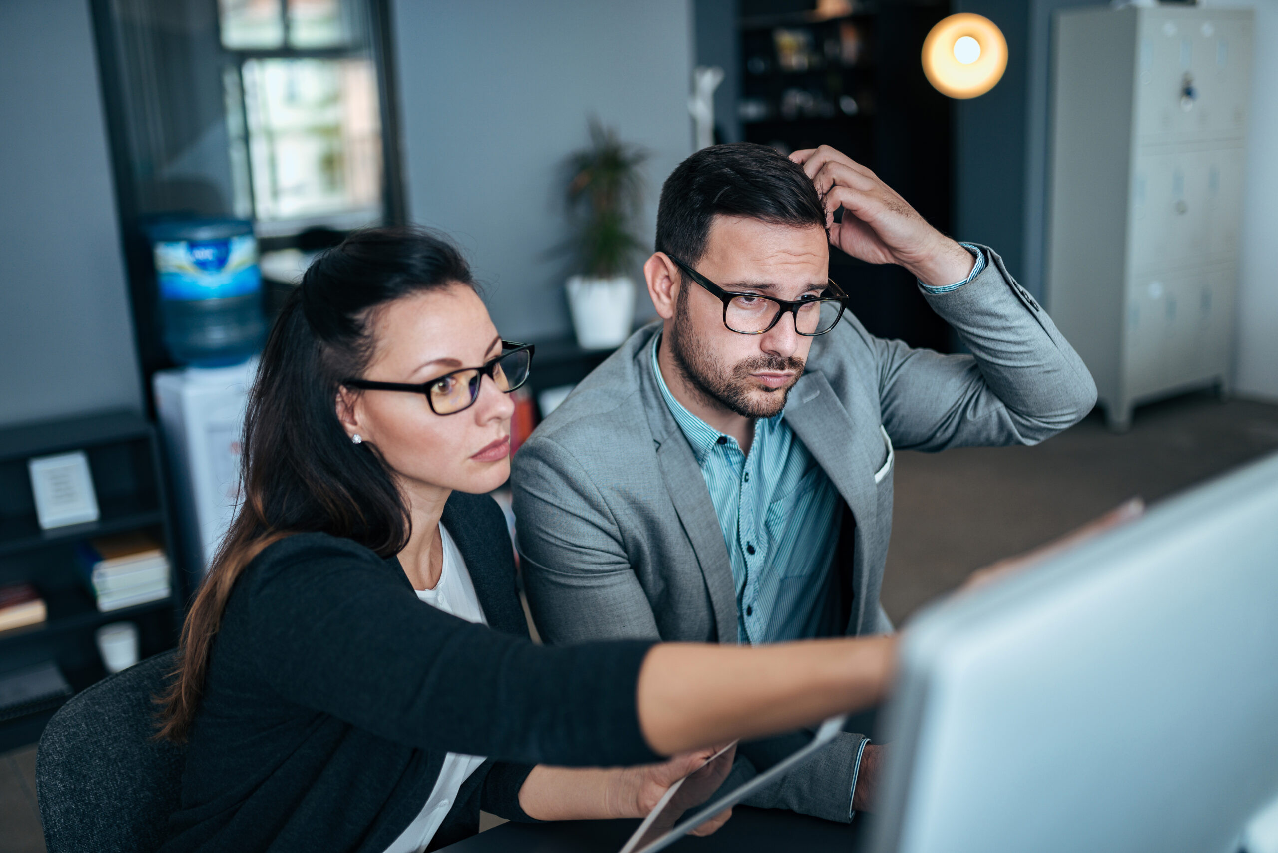 Young concerned couple working together in the office.