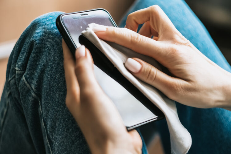 Cleaning the smartphone screen with a fiber cloth from dirt dust