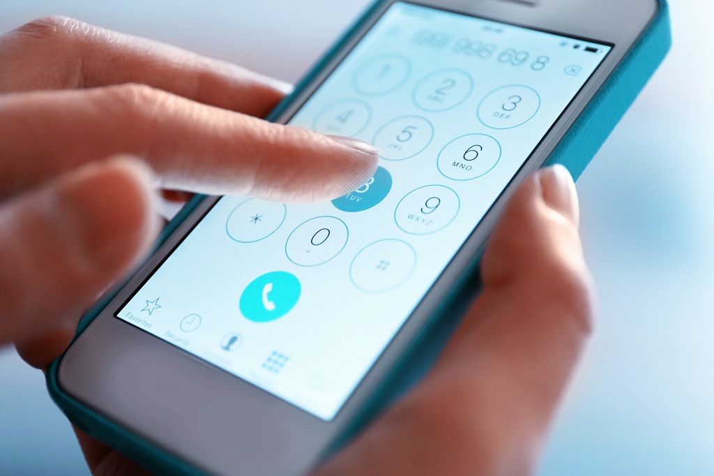 Female hand dialing a number on smartphone to make a call.