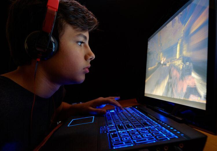 Young male teen playing games on his Laptop
