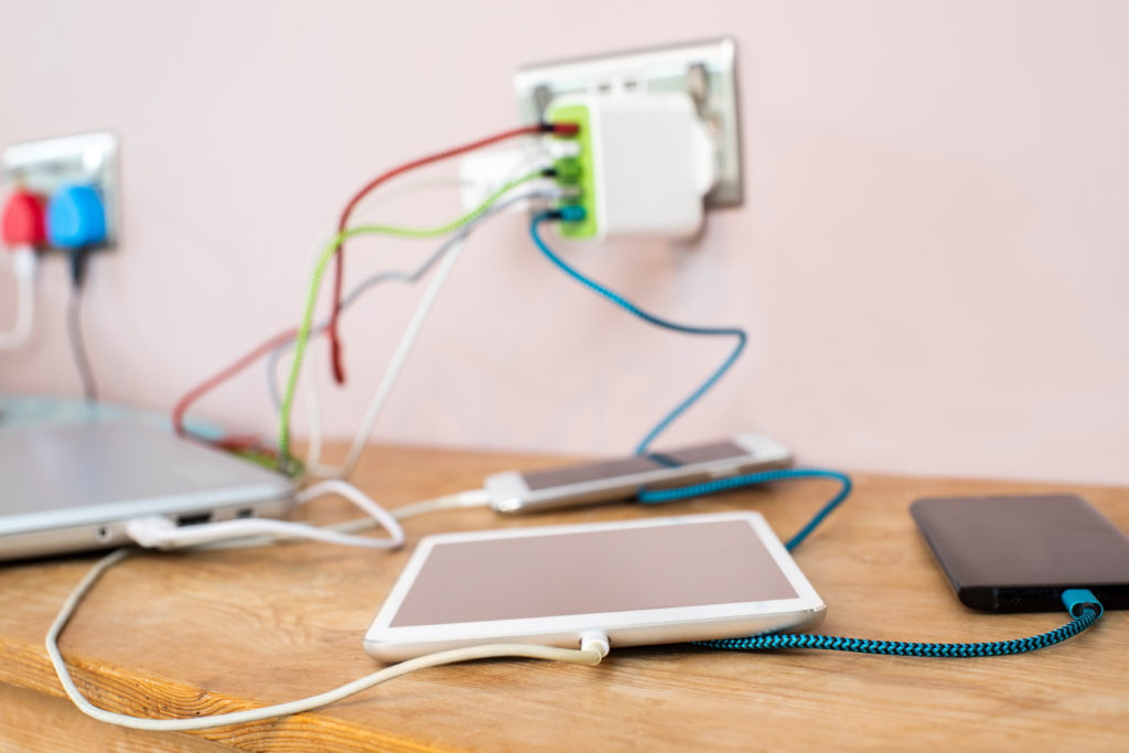 Different electronic gadgets connected to chargers.