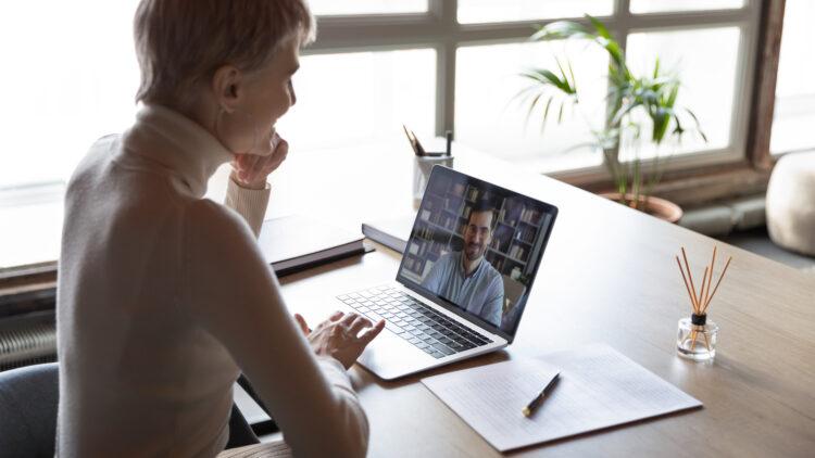 Woman listening to an applicant during remote job interview by video call