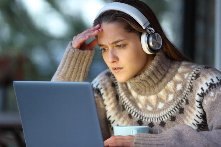 Frustrated woman watching media on laptop
