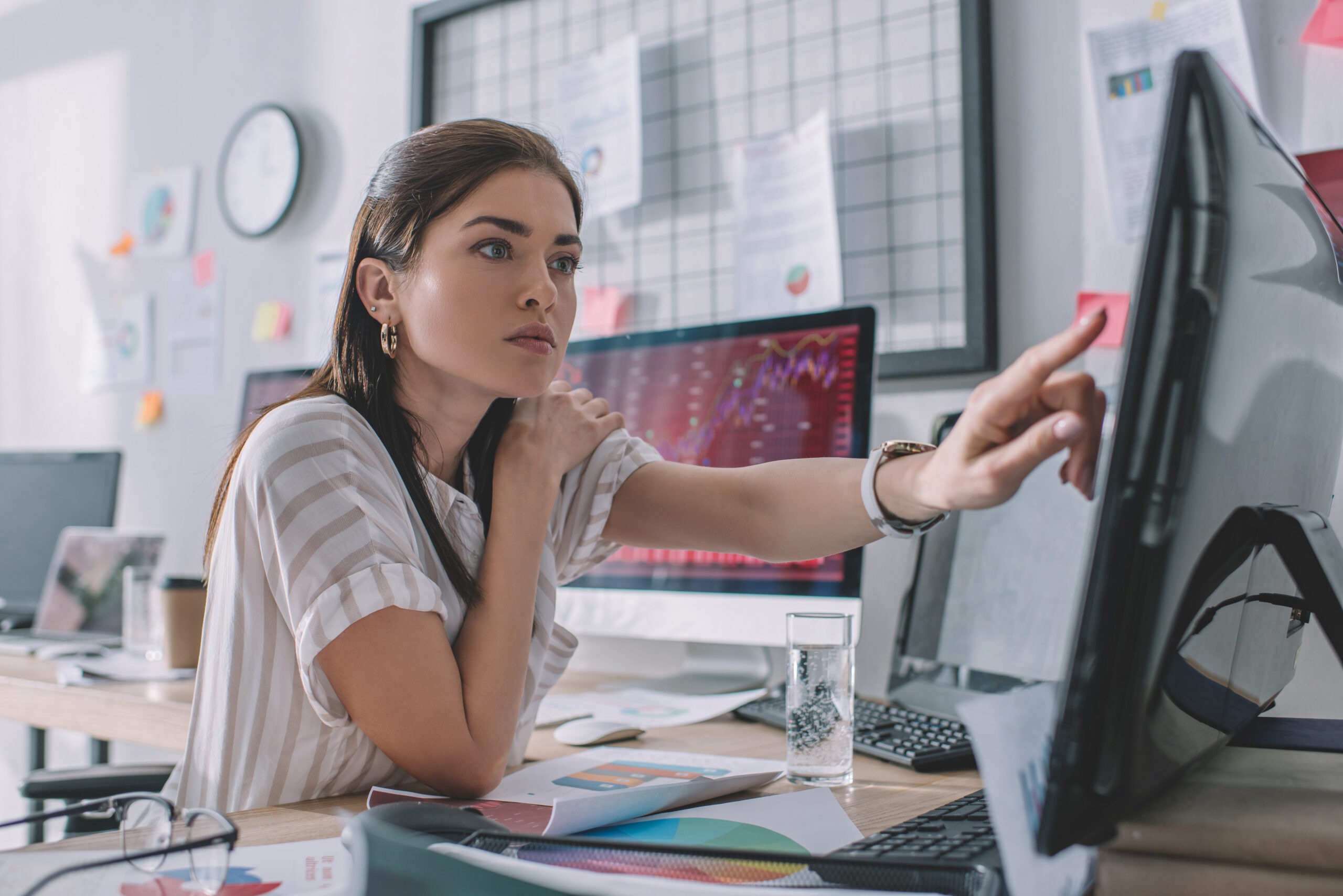 Selective focus of data analyst pointing with finger at computer