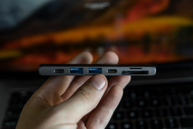 Man's hand holding The USB adapter under the Type-C connector for laptop. 