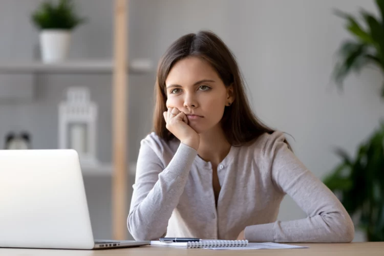 displeased young woman working at laptop