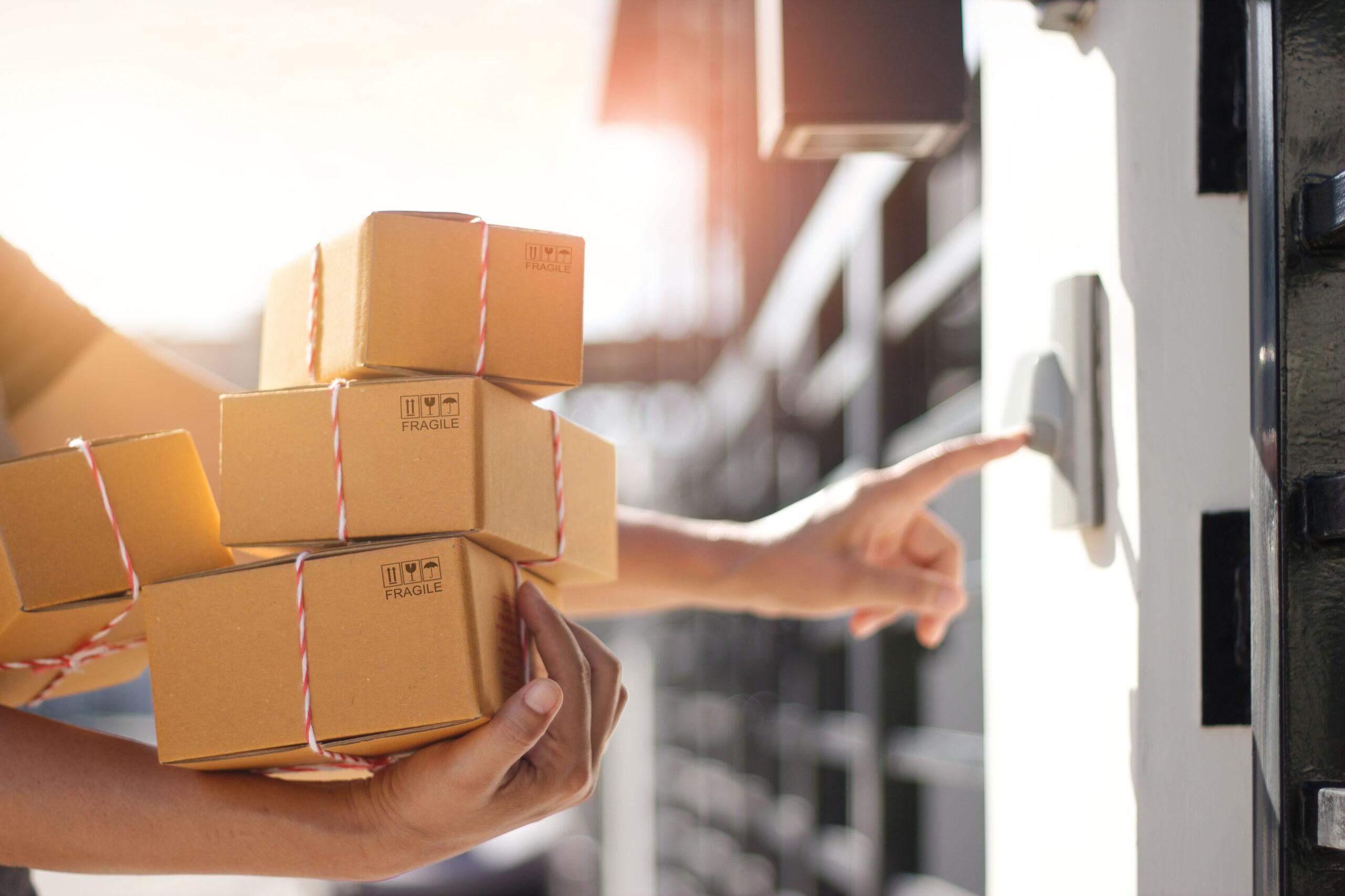 Delivery man holding parcel boxes and ring the doorbell on the customer's house