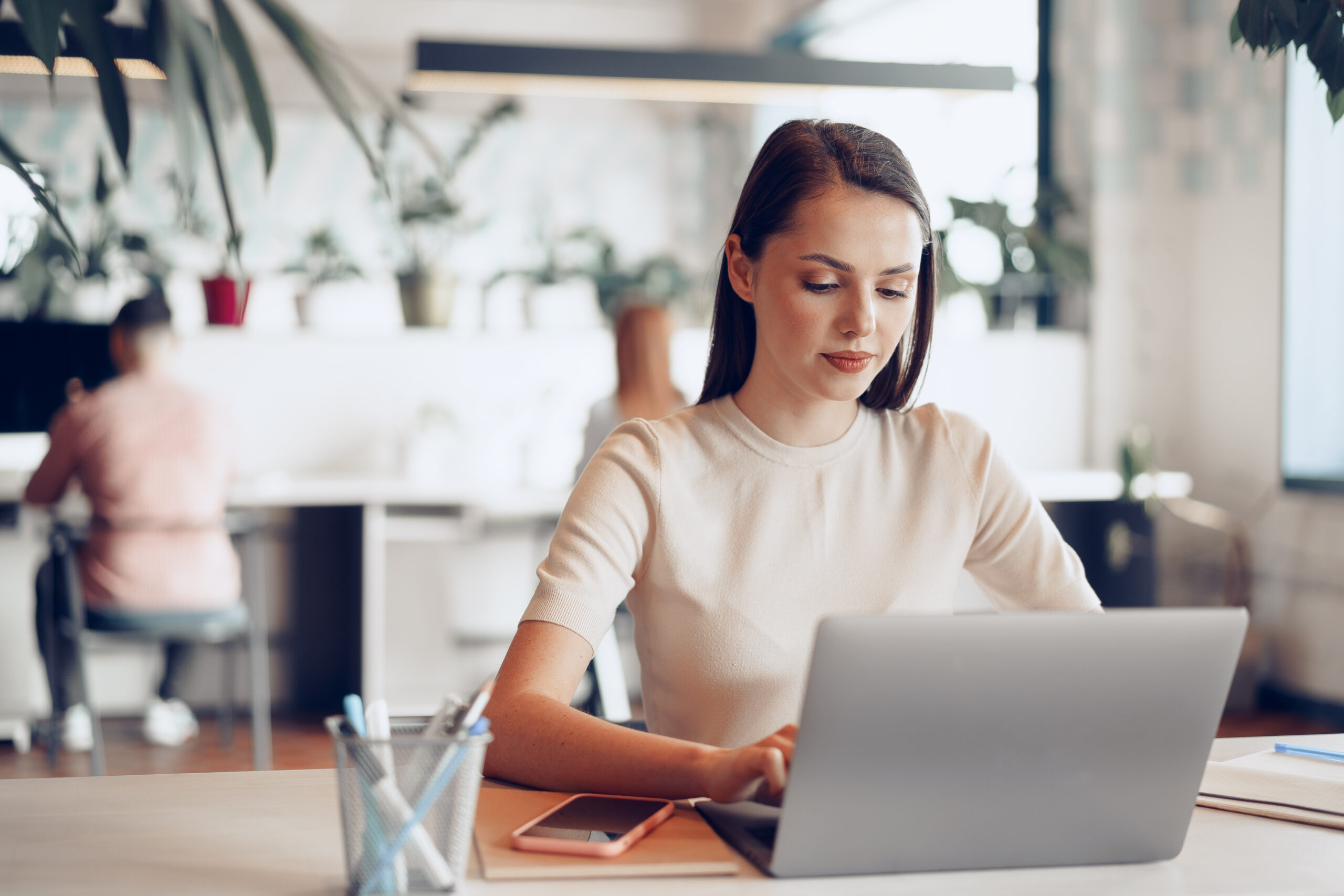 Young attractive businesswoman working on laptop in office