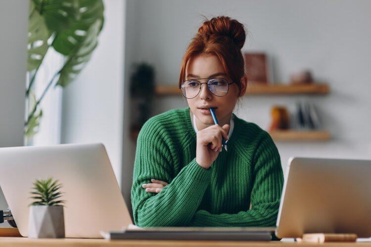 pretty female redhead using electronic devices while working from home