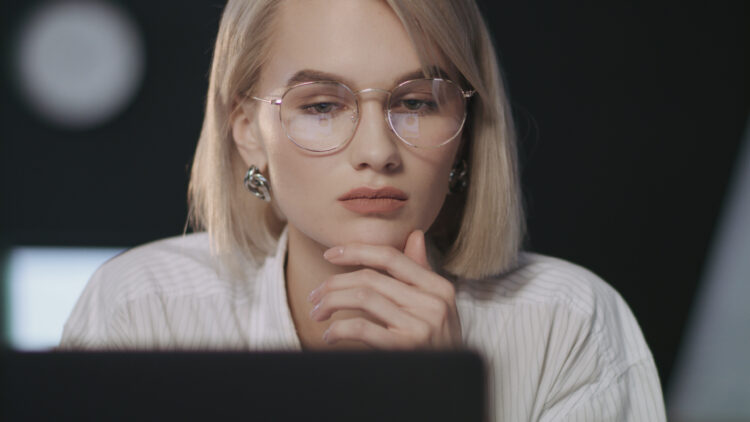 business woman looking laptop screen in dark office