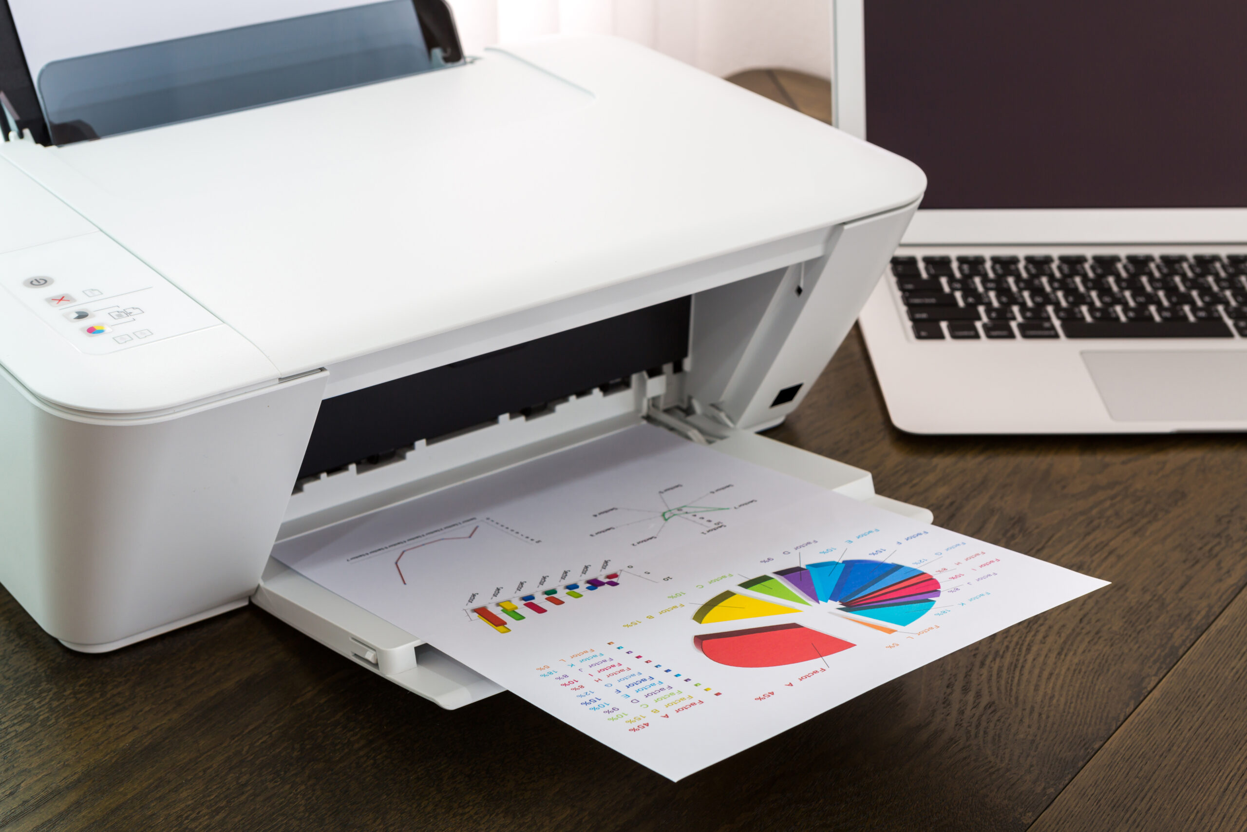 laptop and printer on wooden table