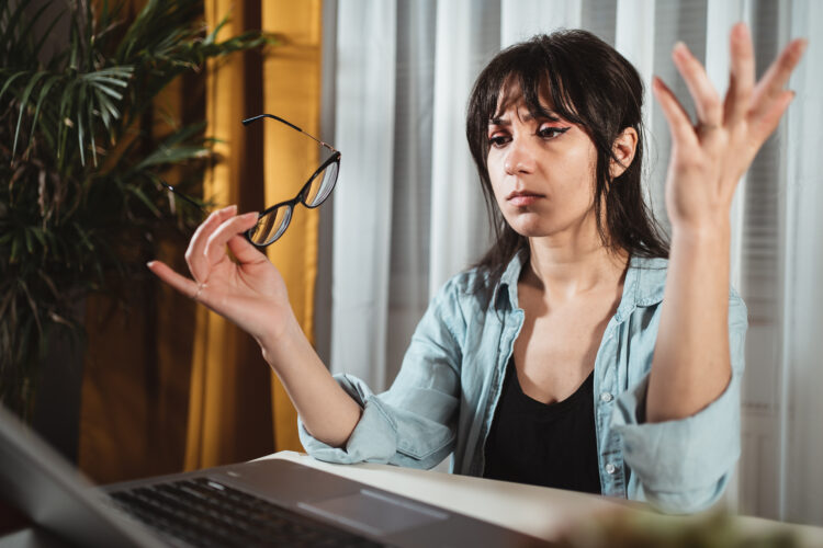 Annoyed young woman with disgust look at laptop screen. 