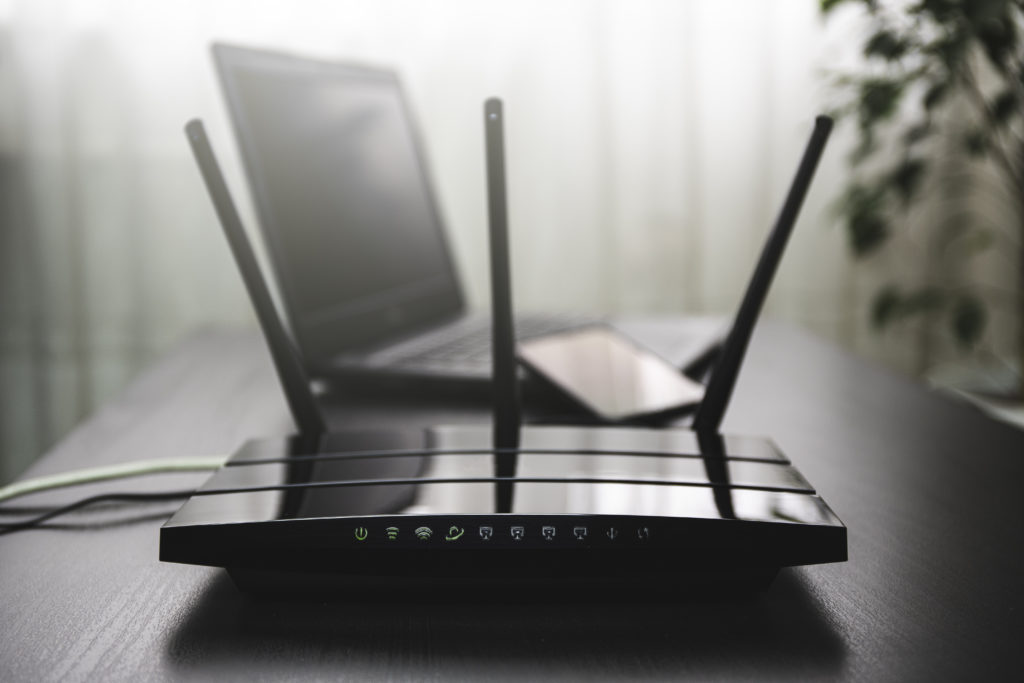 WIFI router connected to the internet on table and laptop