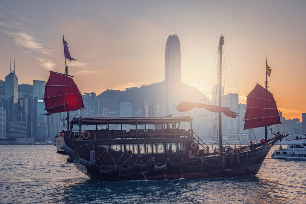 Small ship in Hong Kong harbour at sunset time.