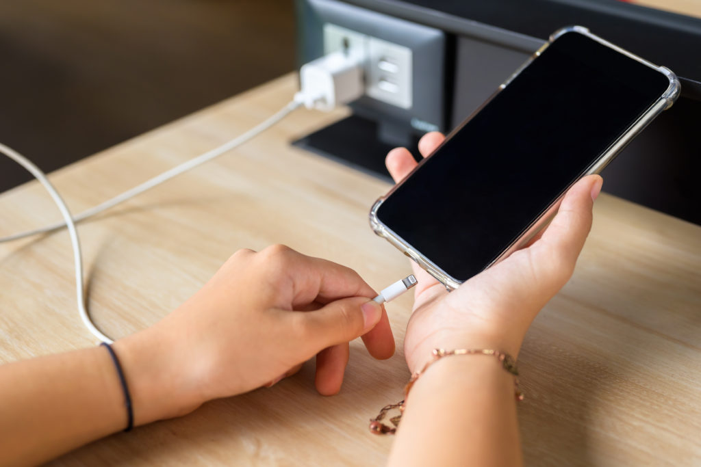 Hand going to charge mobile phone battery