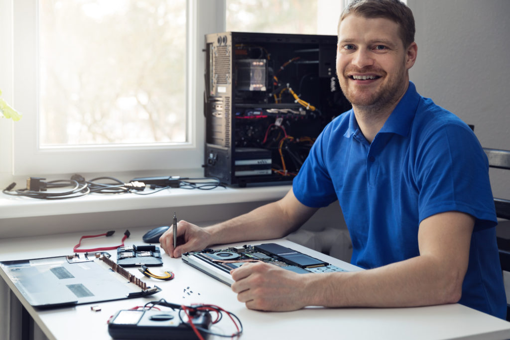 Electronics technician smiling while at work.